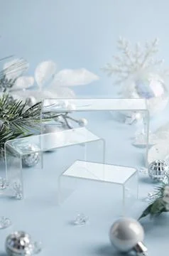 Three clear acrylic podiums framed by winter foliage and silver ornaments f.. Stock Photos