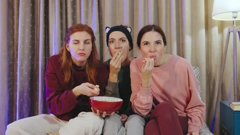 Three close girlfriends are relishing a delightful movie night Stock Footage 296851267