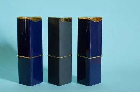 Three closed tubes of lipstick on a blue background Stock Photos