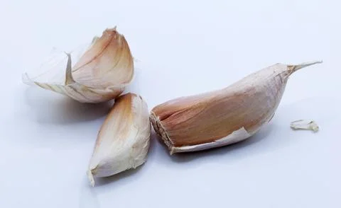 Three cloves of garlic on light background Stock Photos