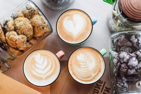 Three coffee with beautiful pattern on foam in cup on table. Top view. Close up Stock Photos