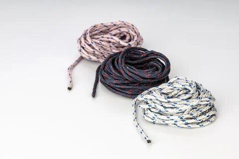 Three Coiled Ropes in White, Navy Blue, and Red Colors on White Background Stock Photos