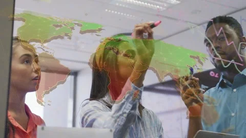 Three colleagues annotating glass world-map, central woman starting writing for 库存影片 334322095