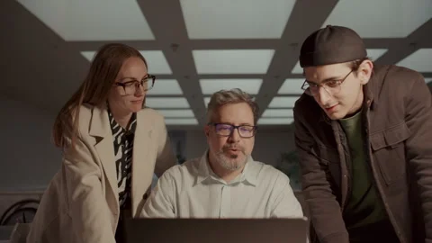 Three Colleagues Collaborating around Laptop, Discussing Project Progress Stock Footage 308617224