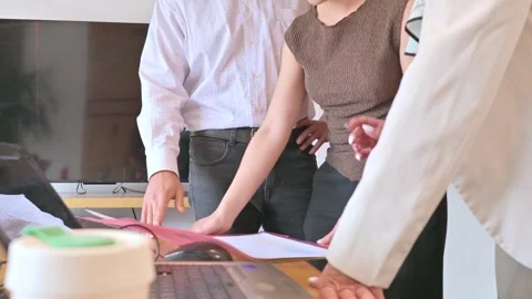 Three Colleagues Collaborating Over Documents in a Bright Office Business M.. 動画素材 335717849