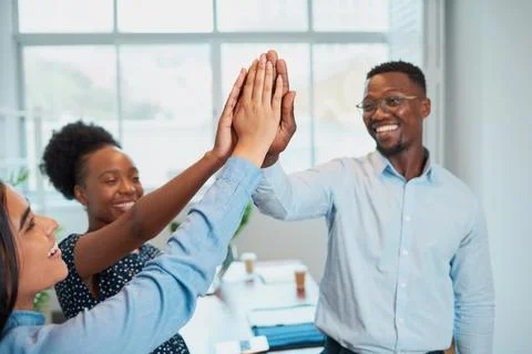 Three colleagues give high five in office, celebrate success, happy teamwork Stock Photos