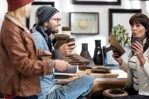 Three colleagues with handcrafted objects discussing Stock Photos