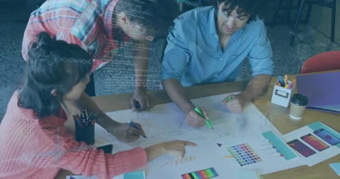 Three colleagues sliding sheet and drawing mind map on table, collaborating for Stock Footage 311216508