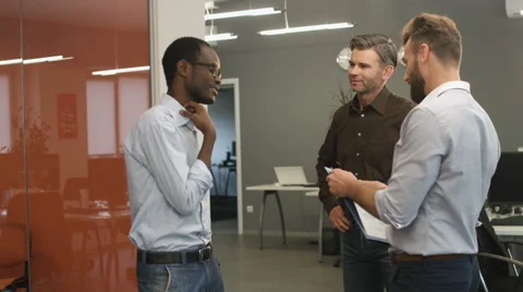 Three colleagues talking to each other Stock Footage 68360946