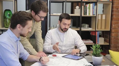 Three colleagues talking with tablet sitting in modern office indoors. Video stock 83026732