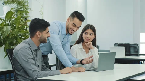 Three colleagues working together discuss computer project teamwork, business Stock Footage 163386078
