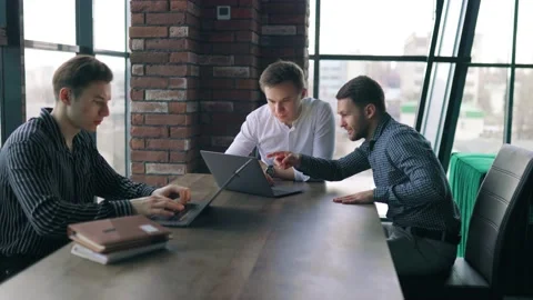 Three colleagues working together on a laptop, receiving guidance from their Stock Footage 237638815