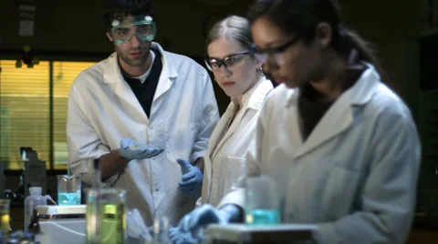 Three college students in a lab conduct some experiments Stock Footage 33878746