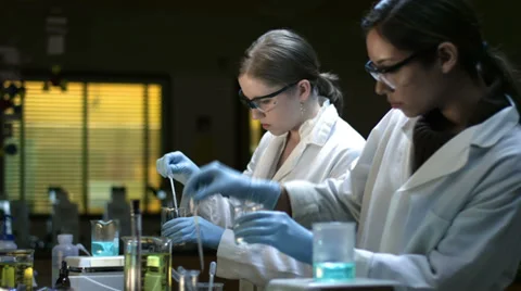 Three college students in a lab conduct some experiments Stock Footage 33878881