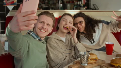 Three College Students Taking Selfie while Enjoying Fast Food Meal at Cafe Stock Footage 335760257