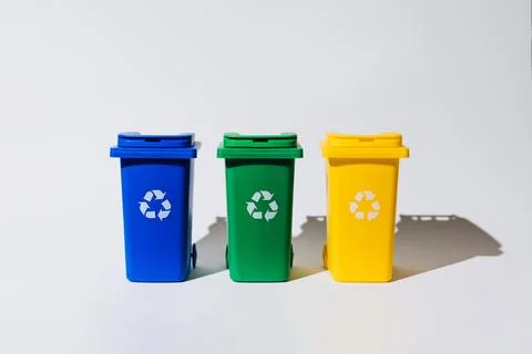 Three color-coded recycle bins arranged in a row, showcasing eco-friendly w.. Stock Photos
