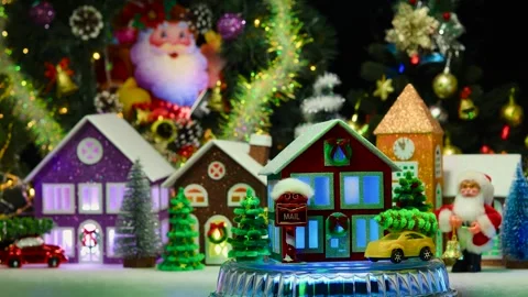 A three-color house on a stand surrounded by green Christmas trees and cars Stock Footage 293427727