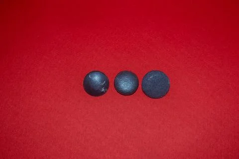 Three colored buttons on a red background, garment accessories Stock-Fotos