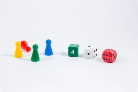 Three colored dice and four playing stones isolated on white background Stock Photos