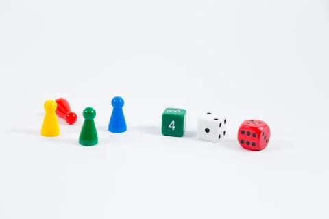 Three colored dice and four playing stones isolated on white background Stock Photos