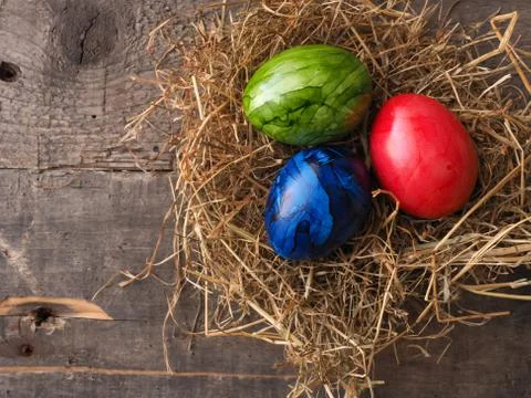Three colored Easter eggs in a nest Stock Photos