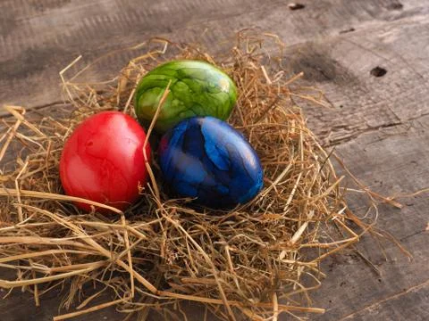 Three colored Easter eggs in a nest Stock Photos