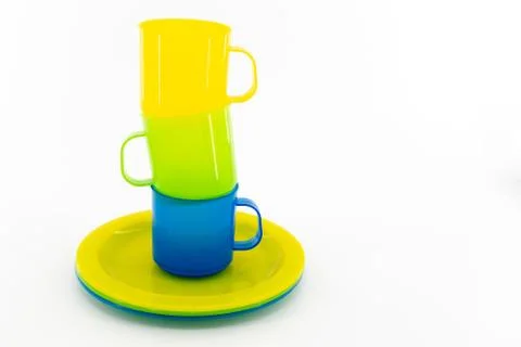 Three colored mugs and three colored saucers on a white background Stock Photos