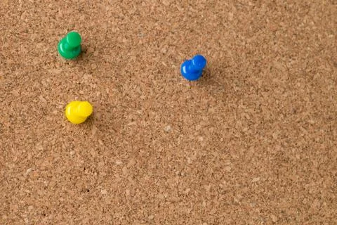 Three Colored Thumb Tacks on Cork Board Stock Photos