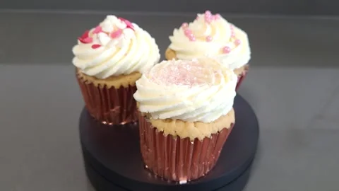 Three colorful cupcakes revolve Stock Footage 244924826