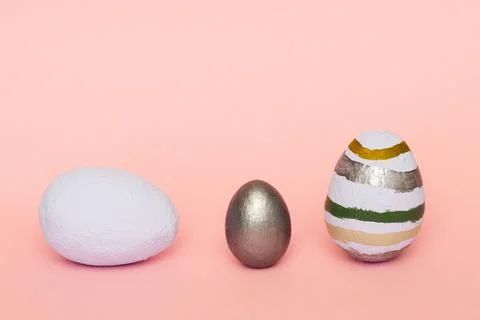 Three colorful decorative painted easter eggs on pink surface Stock Photos