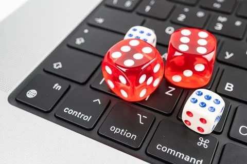 Three colorful dice on a computer keyboard with dots from 1 to 6 Scene suit.. Stock Photos