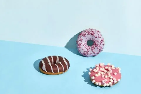 Three Colorful donuts on a blue background Stock Photos