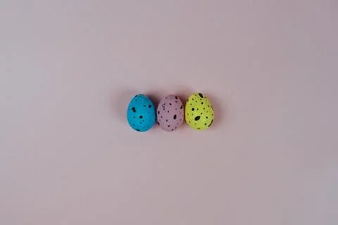 Three colorful Easter quail eggs isolated on pink background. Happy Easter and Stock Photos