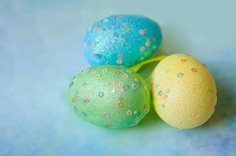 Three colorful handmade easter eggs on blue background Stock Photos