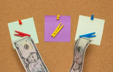 Three colorful notes with pushpins and clothespins with money isolated on a c Stock Photos