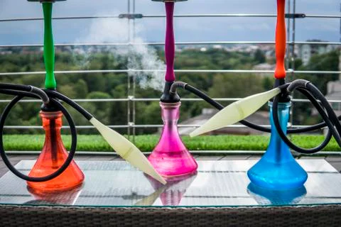 Three colors hookahs on table in hookah lounge in a day. Stock Photos