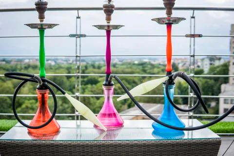 Three colors hookahs on table in hookah lounge in a day. Stock Photos