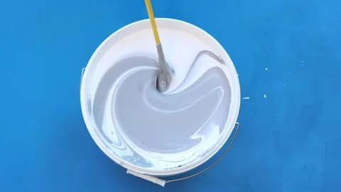Three colors of paint are mixed in bucket of paint with mixer. Stock Footage 249152454