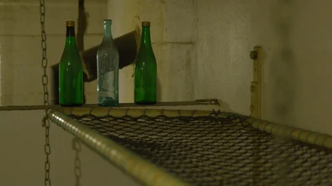 Three coloured bottles sitting on a ledge Stock Footage 121696858