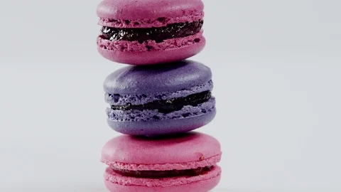Three colourful macarons, which lay on each other, are rotating before the Stock Footage 72250879