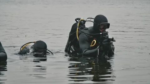 Three combat swimmers with weapon moving to the riverbank cautiously in slo-mo Stock-Footage 121871311