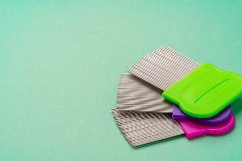 Three combs for lice removing on green background Stock-Fotos