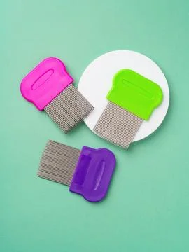 Three combs for lice removing on green background Foto stock