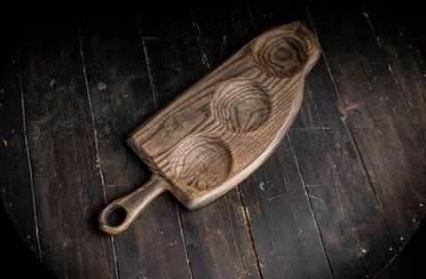 Three-compartment serving board made with hardwood on the old rustic table. Stock Photos