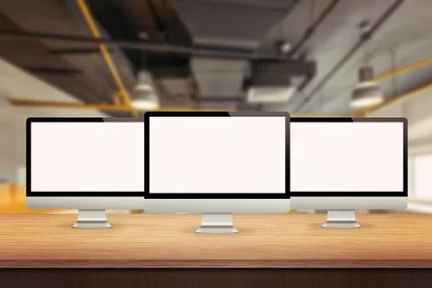 Three computer displays on table in office interior Stock Photos