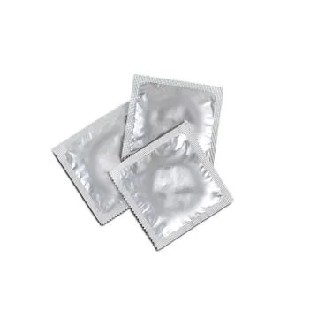 Three condoms isolated on white background. Close up Fotos Stock