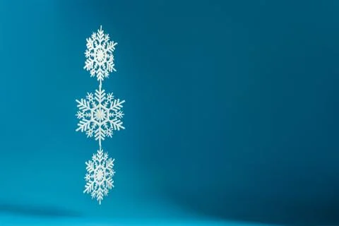 Three connected snowflakes on a blue background with copy space. Stock Photos