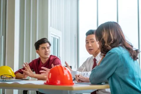Three Construction team having business meeting on table with engineer equipm Stock Photos