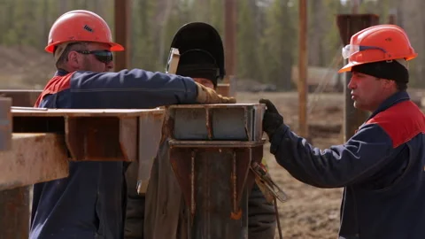 Three construction workers check the level of a pile at the construction site Stock Footage 246754507