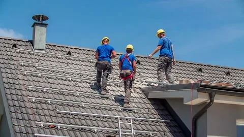 Three Construction Workers Take a Break During Solar Panel Mounting Job on Stock Footage 150195443